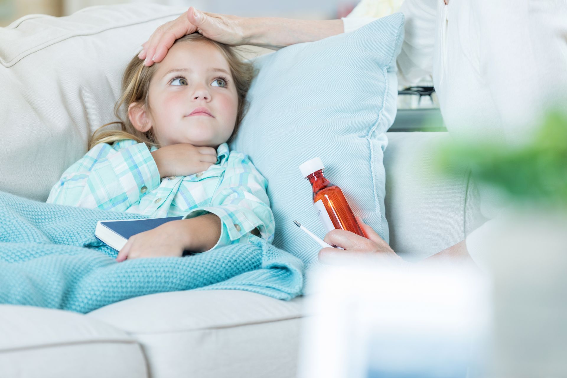 Sick child with parent feeling their head for a fever