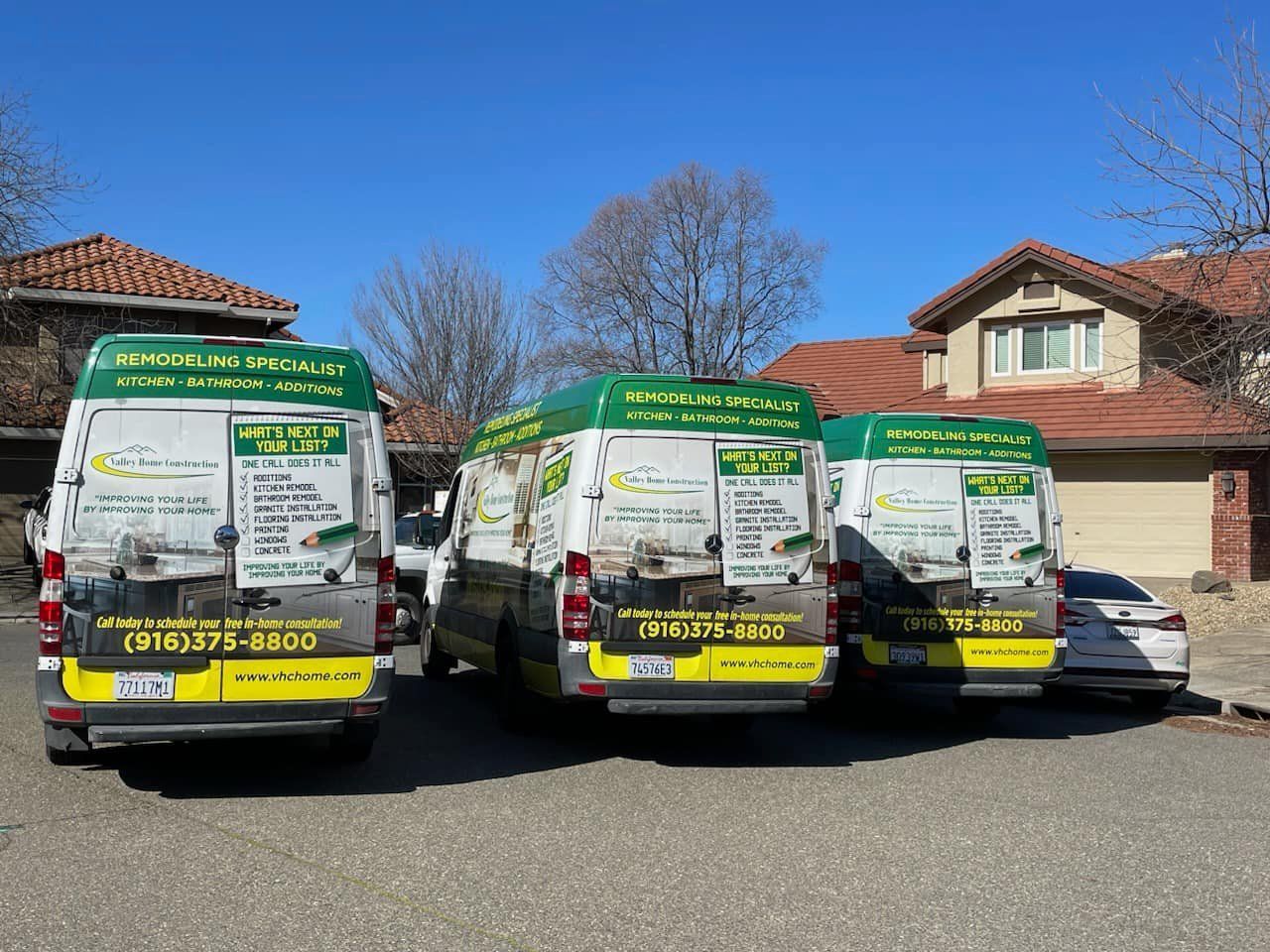 Three vans are parked in front of a house.