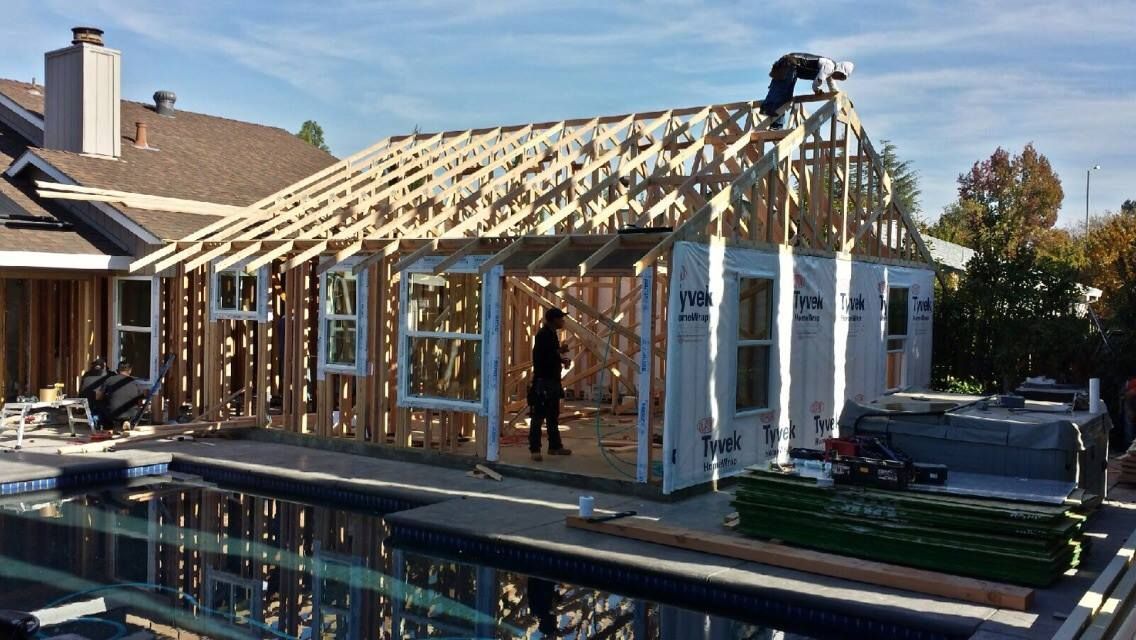 A house is being built next to a swimming pool.