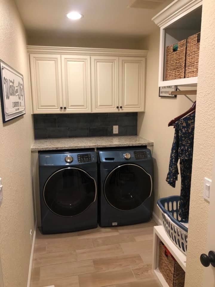 A laundry room with two washers and two dryers.