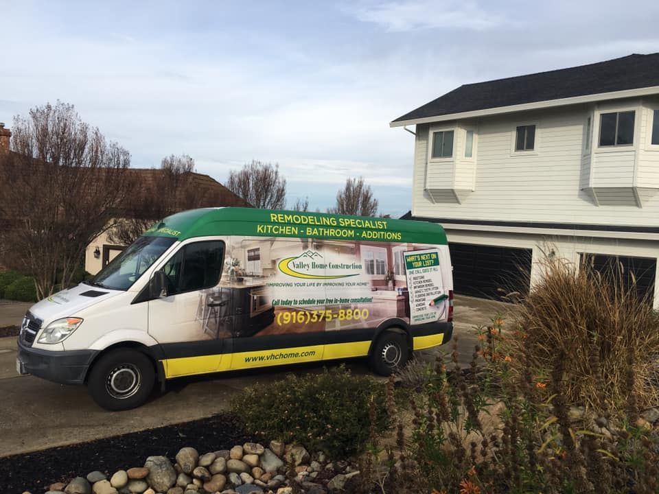A white van is parked in front of a house.