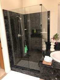 A bathroom with a walk in shower and a sink.