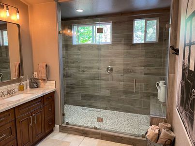 A bathroom with a walk in shower and a sink.