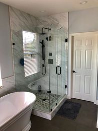A bathroom with a tub , shower , and window.