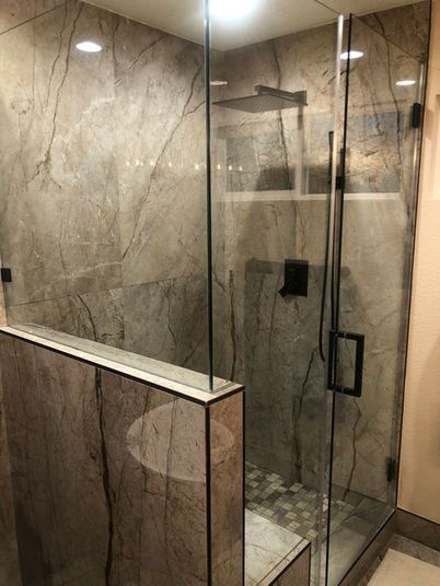 A bathroom with a walk in shower and a sink.