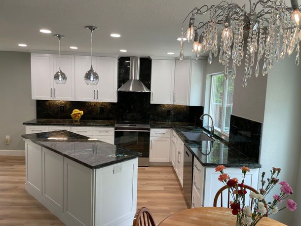 A kitchen with a table and chairs and a chandelier hanging from the ceiling.