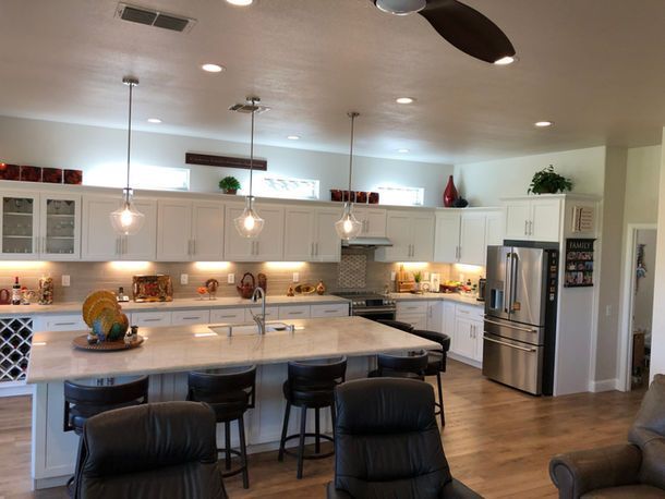 A kitchen with white cabinets and stainless steel appliances