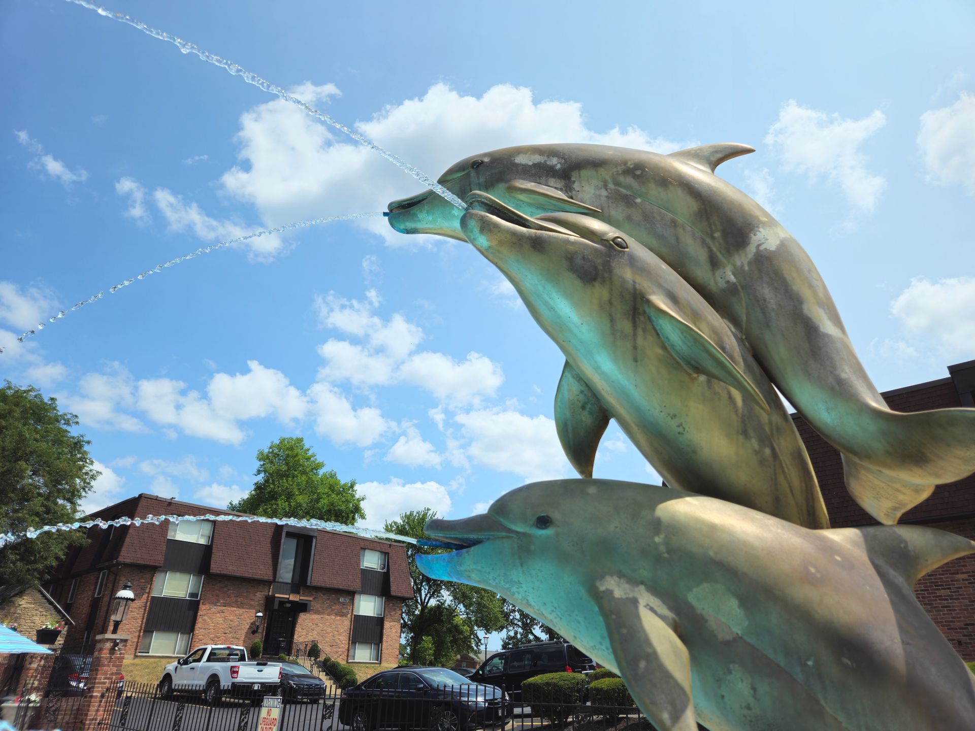 A statue of three dolphins spraying water from their mouths