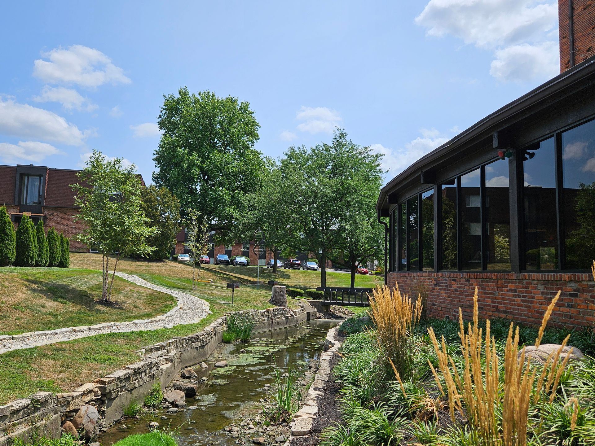 A brick building with a pond in front of it