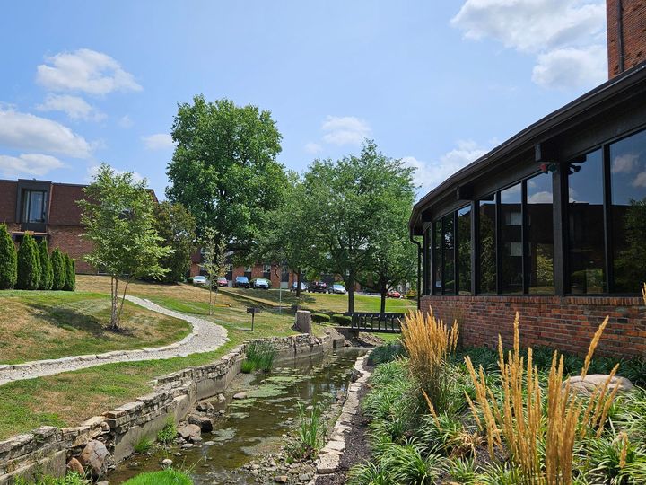 A brick building with a pond in front of it