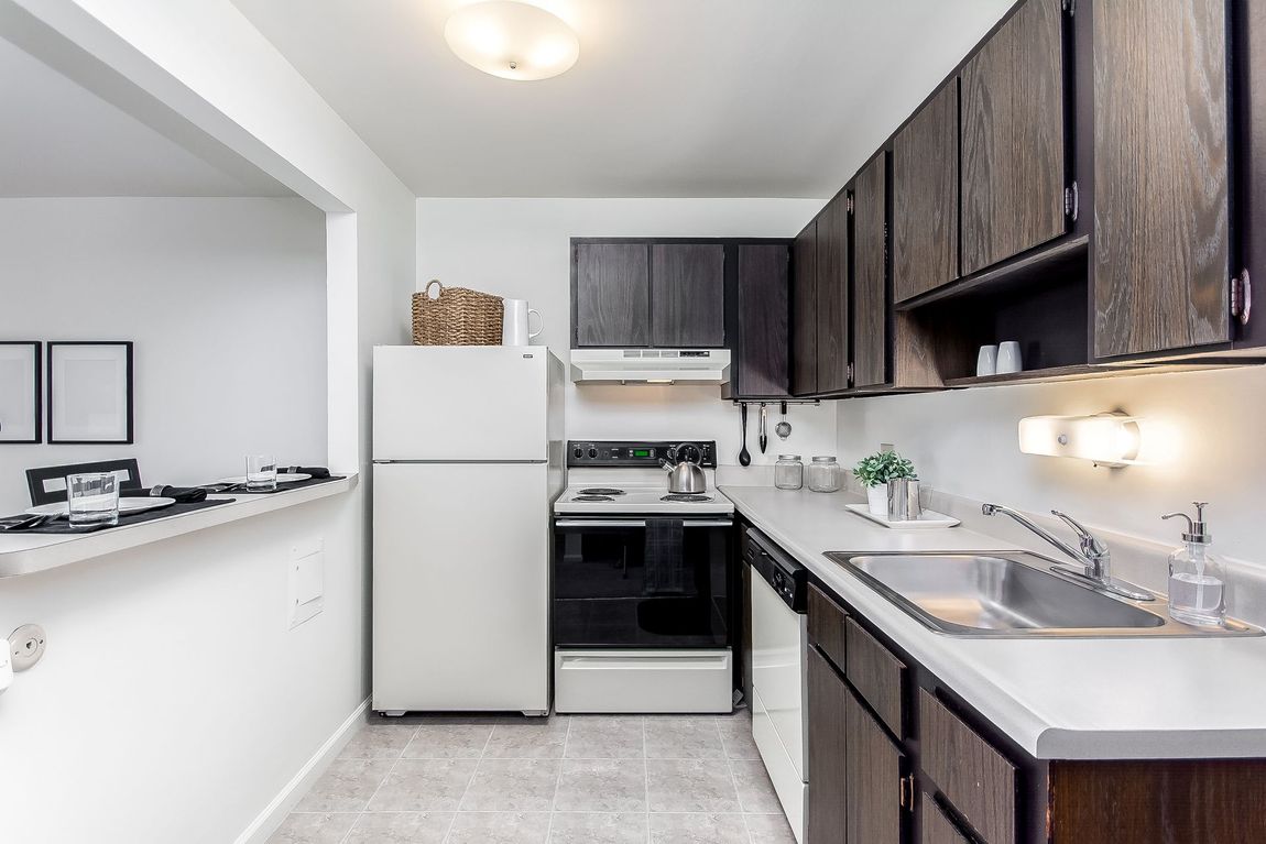 A kitchen with wooden cabinets and a white refrigerator