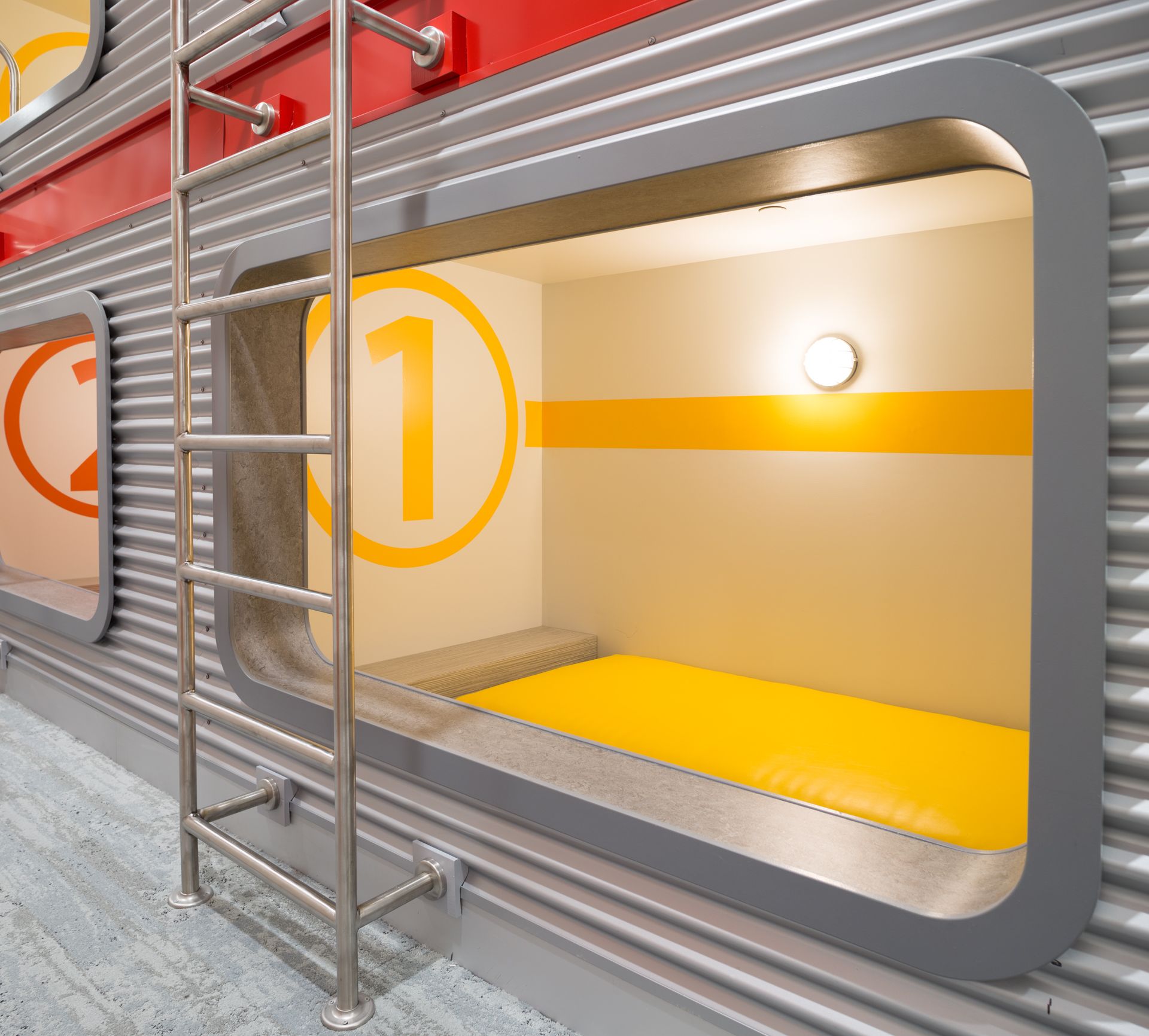 Capsule hotel room with yellow bed, number