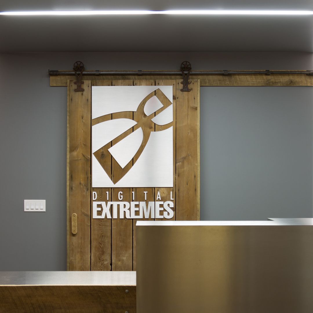 Wooden sliding door with Digital Extremes logo and reception desk.