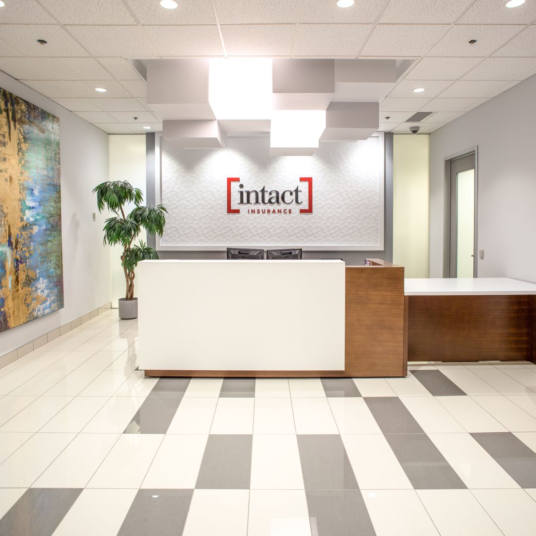 Office reception area with a white and wood front desk, tile floor, and