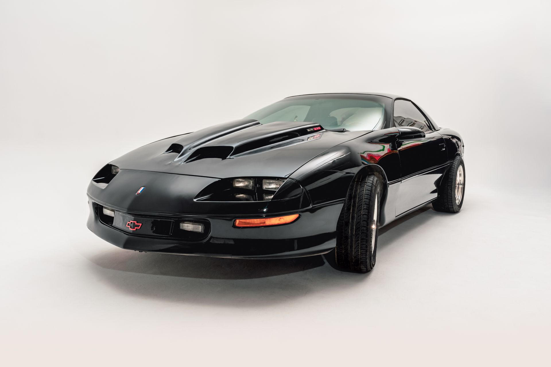 Black Chevrolet Camaro with a scoop hood, on a white background.