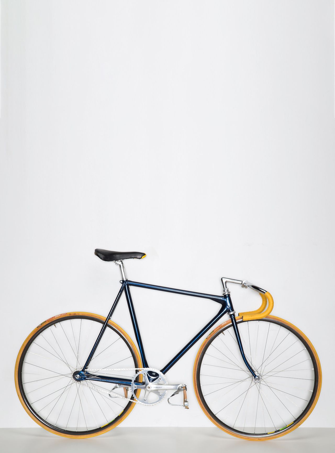 Blue and tan fixed-gear bicycle against a white background.