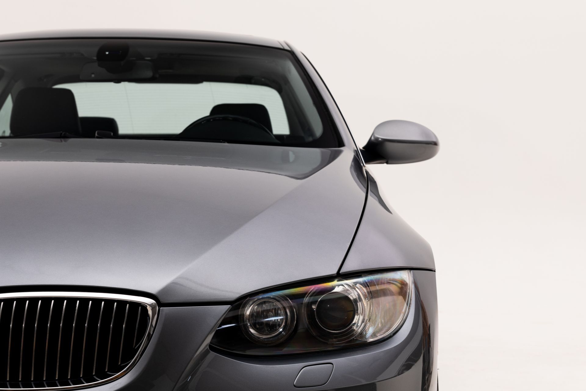 Gray car, front view, headlights and grille visible, on a white background.