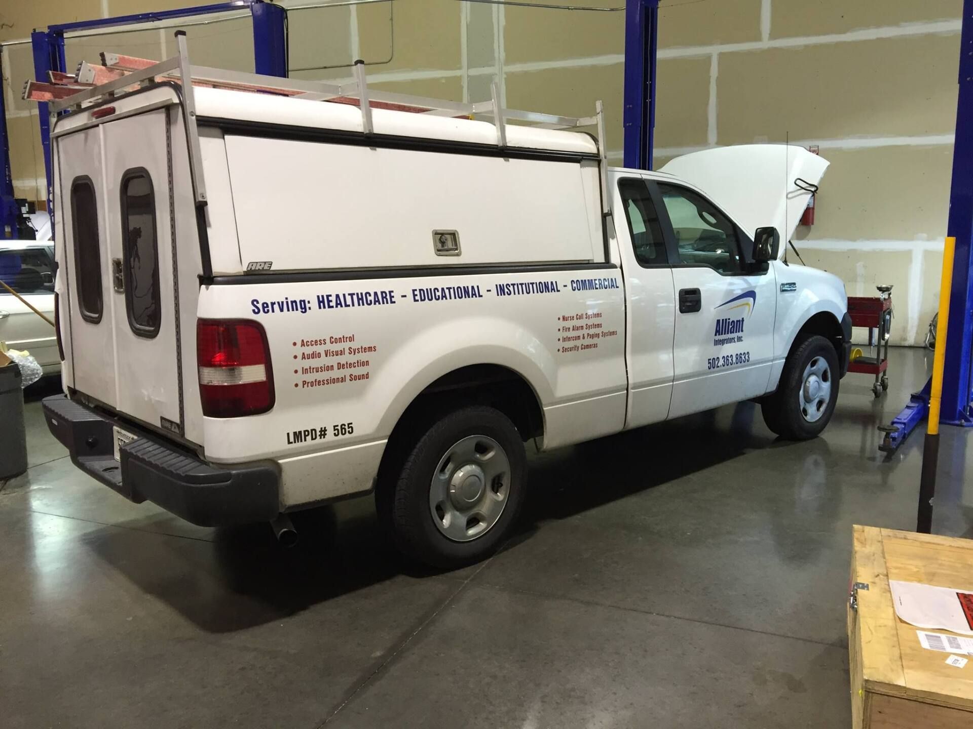 a white truck is parked in a garage with the hood open