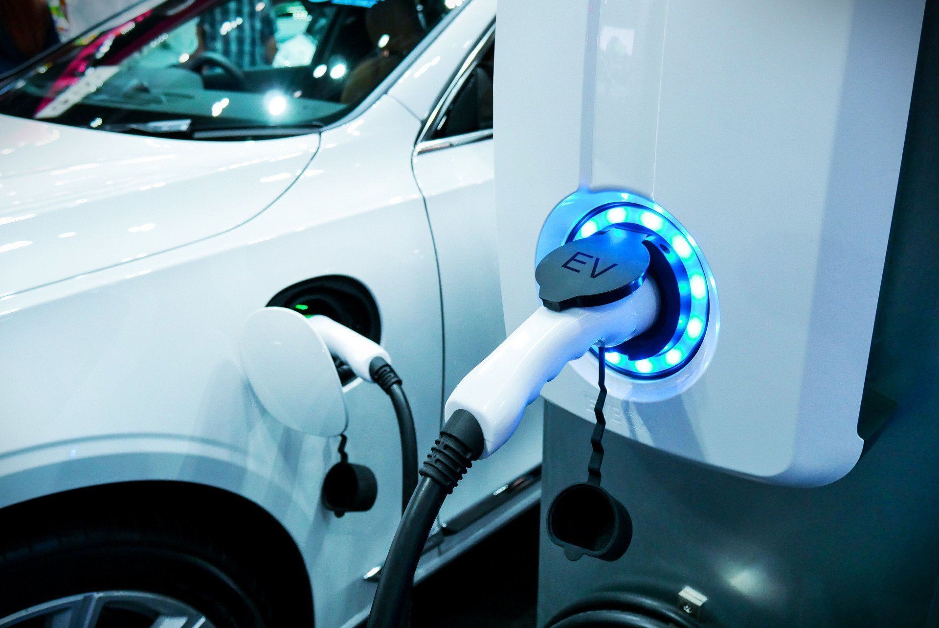 a white electric car is being charged at a charging station .