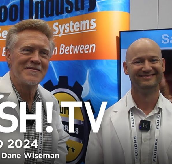 Two men in lab coats smile at a camera. 
