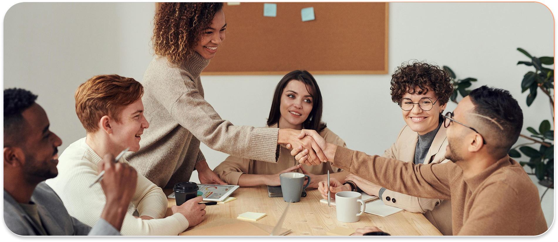 People in a business meeting shaking hands to greet each other.