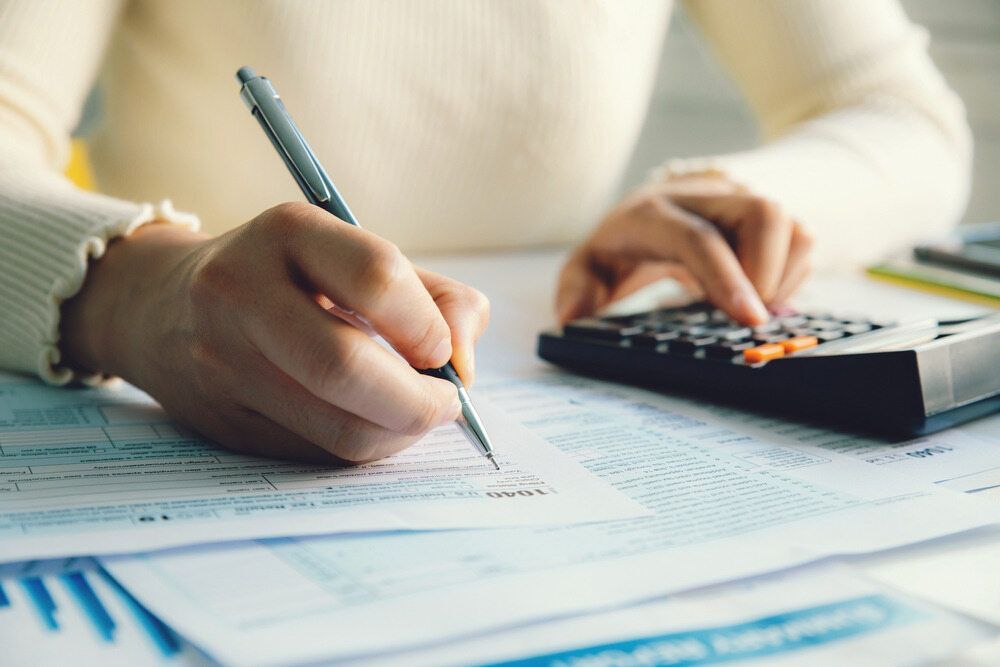 Person Calculating Taxes — SDM Accounting & Taxation Services In Cooroy, QLD