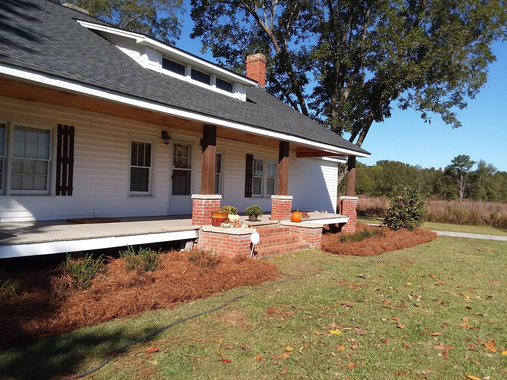 a white house with a black roof and a porch