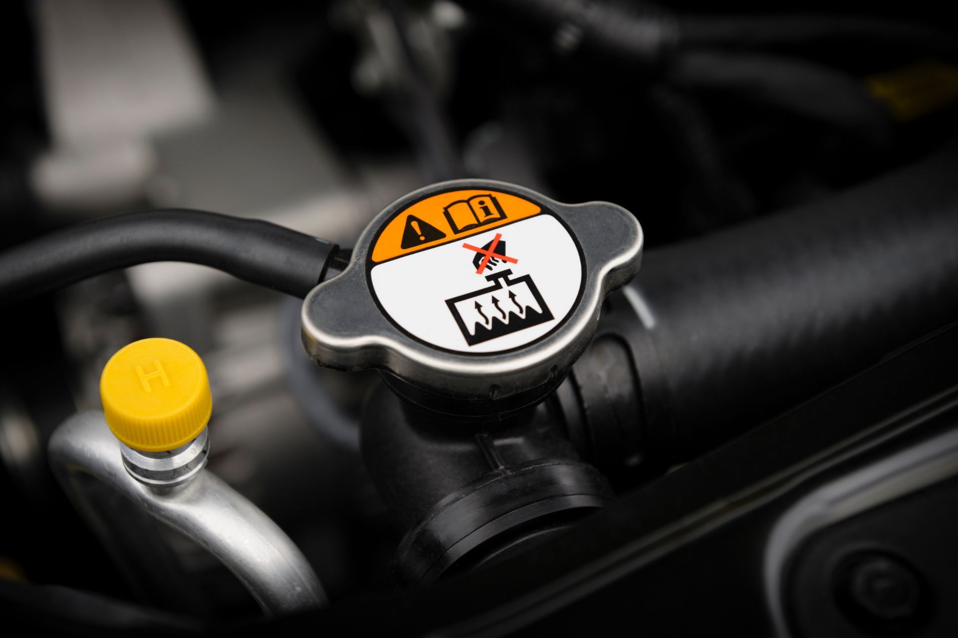 A close up of a radiator cap on a car engine.