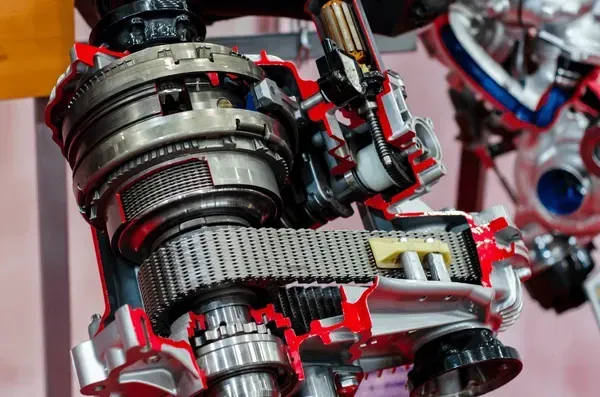 A cut in half model of a gearbox with a chain attached to it.