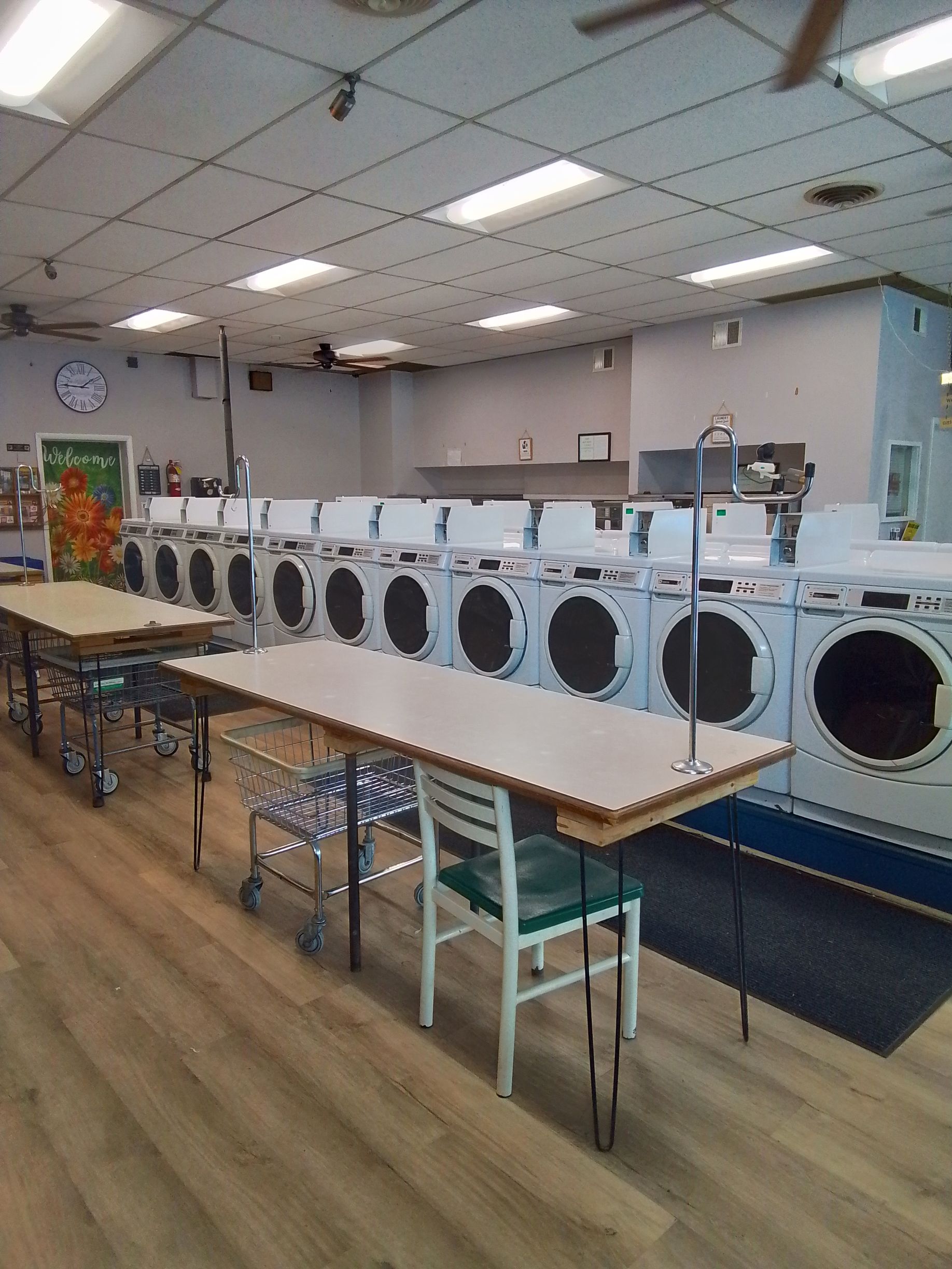 A laundromat with a lot of clothes hanging on racks.