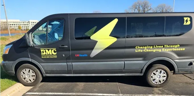 Black van with green lettering the reads