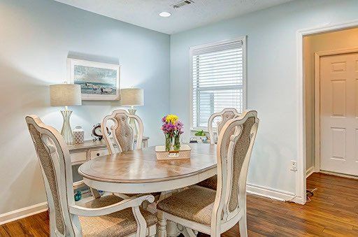 A dining room with a table and chairs and a window.