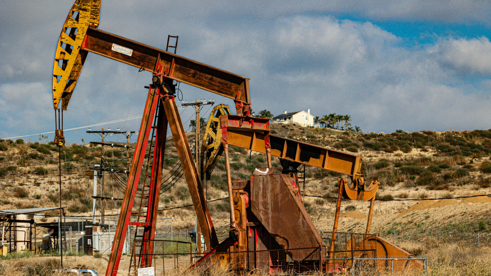 Oil pumpjack in a desert landscape under a blue sky
