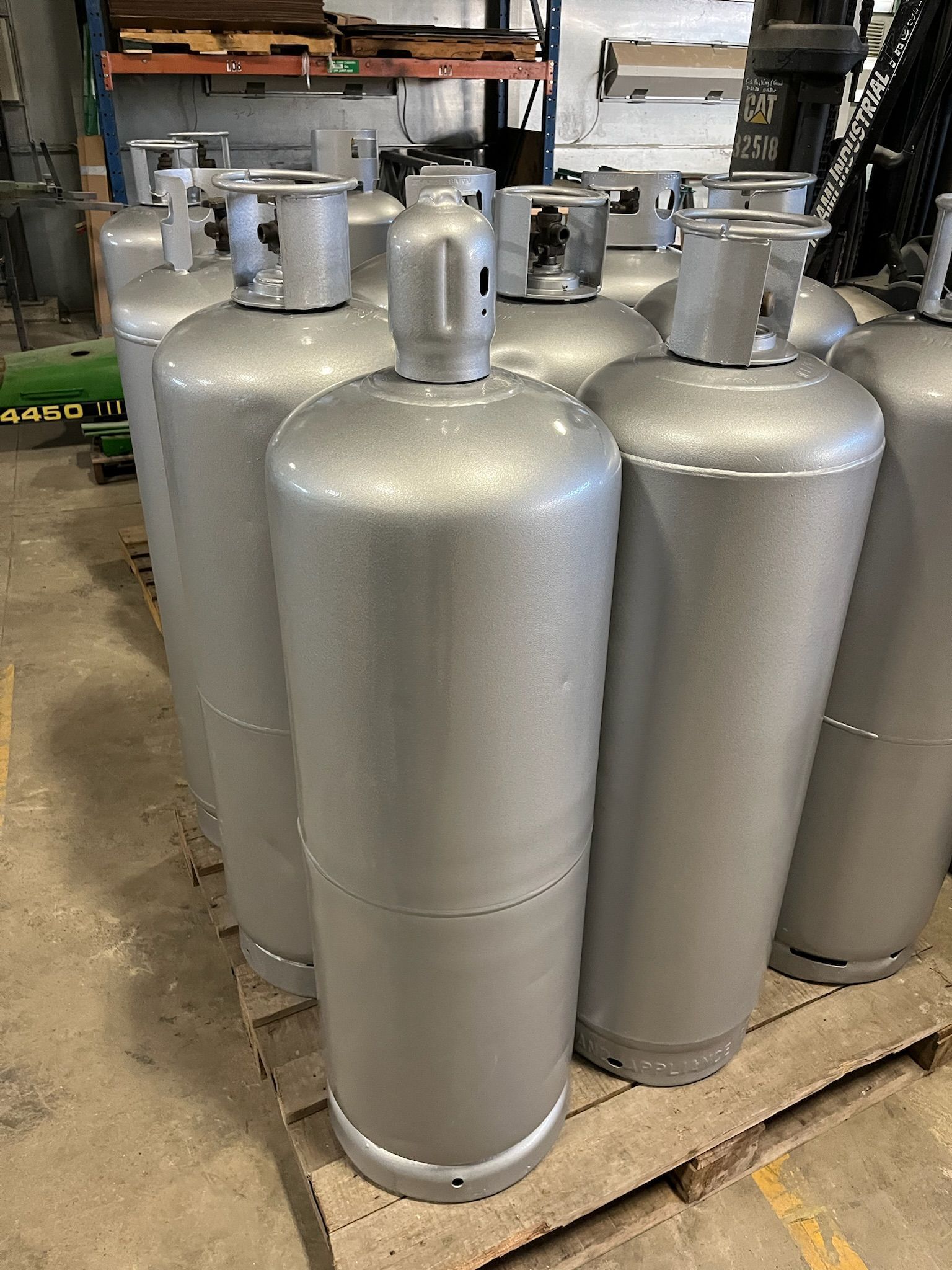 Silver industrial gas cylinders, clustered together indoors.