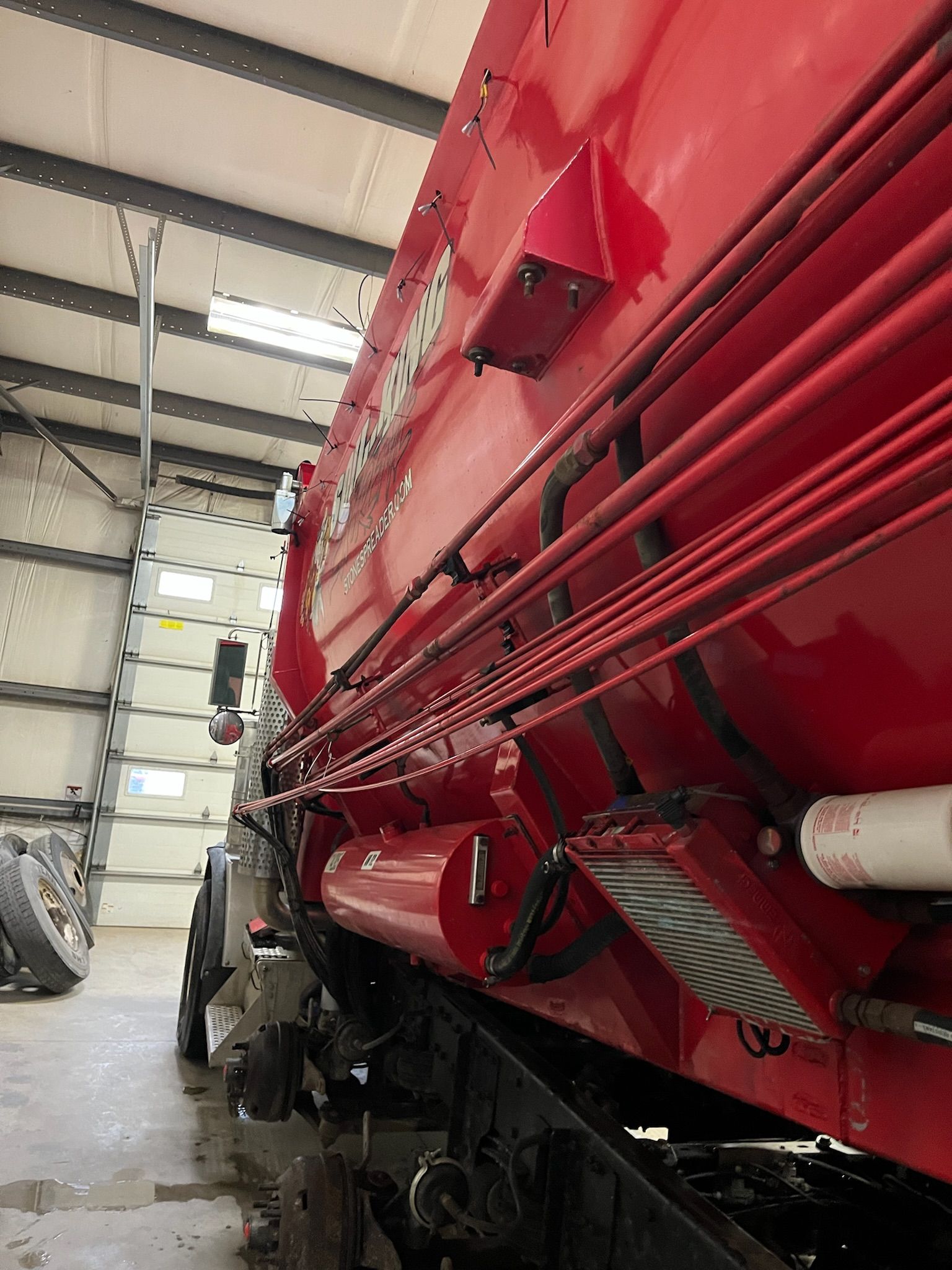 Red agricultural truck in a shed.
