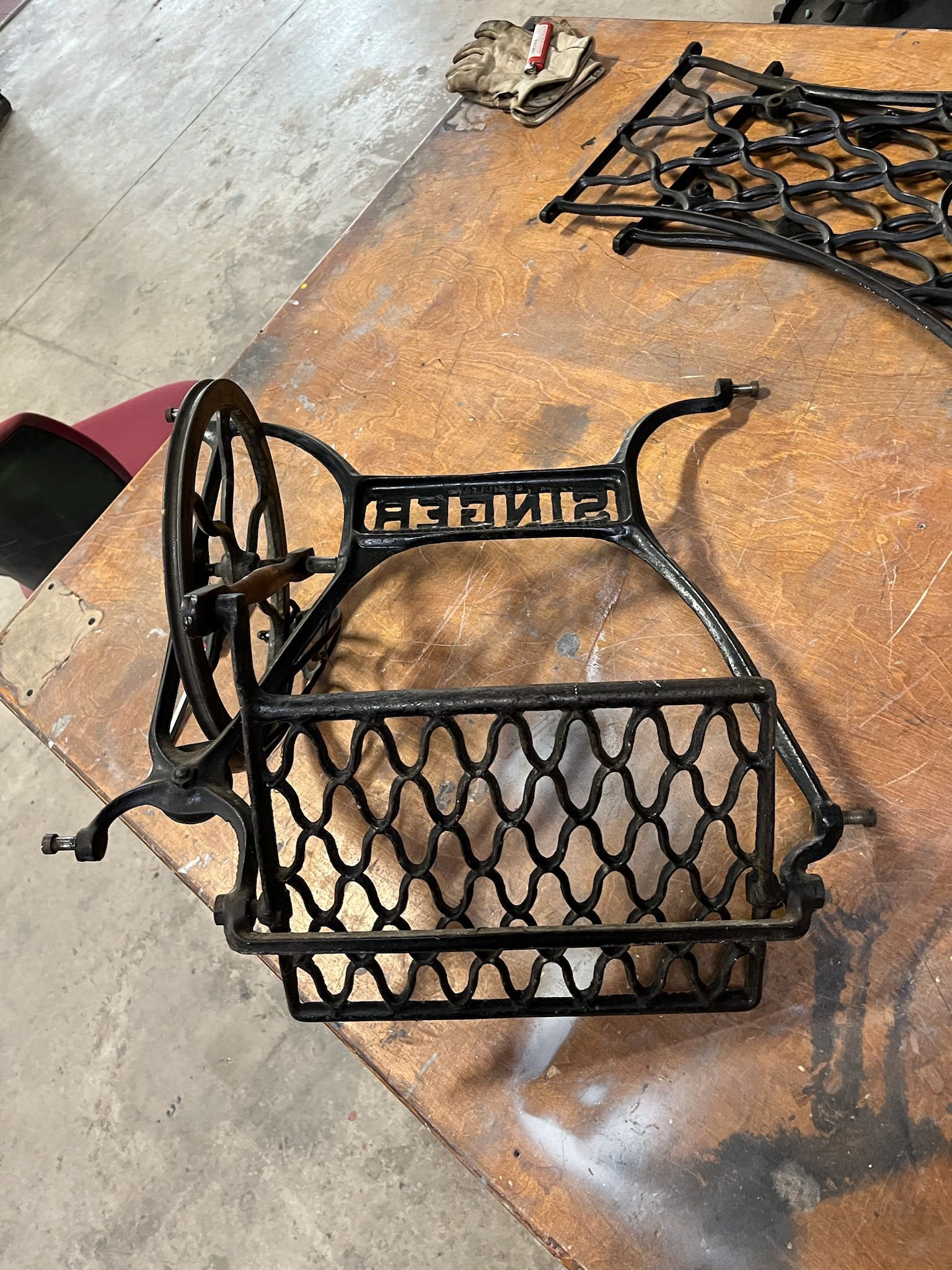 Black Singer sewing machine base on a wooden work surface.