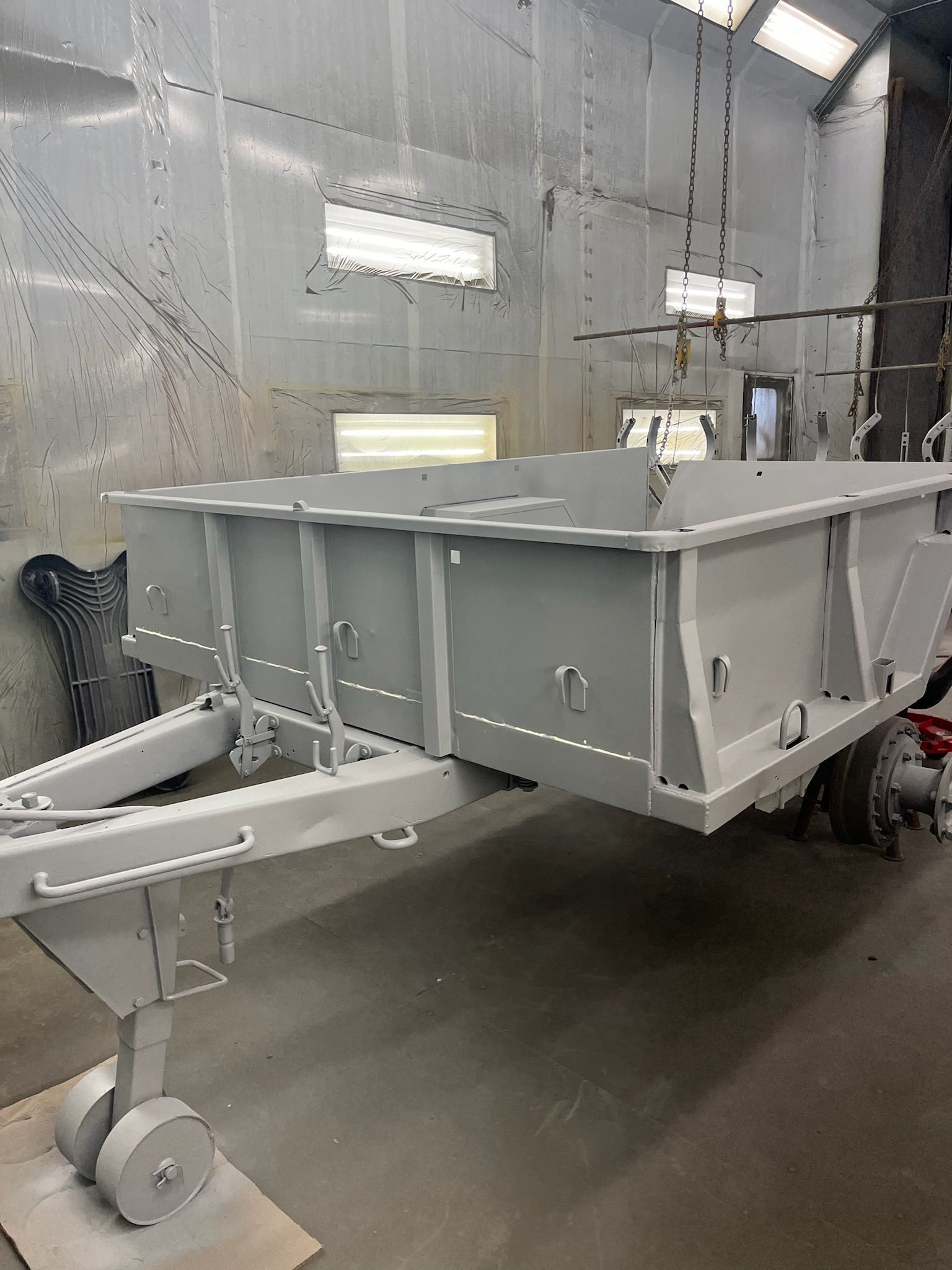 Gray trailer in a gray indoor setting, freshly painted.