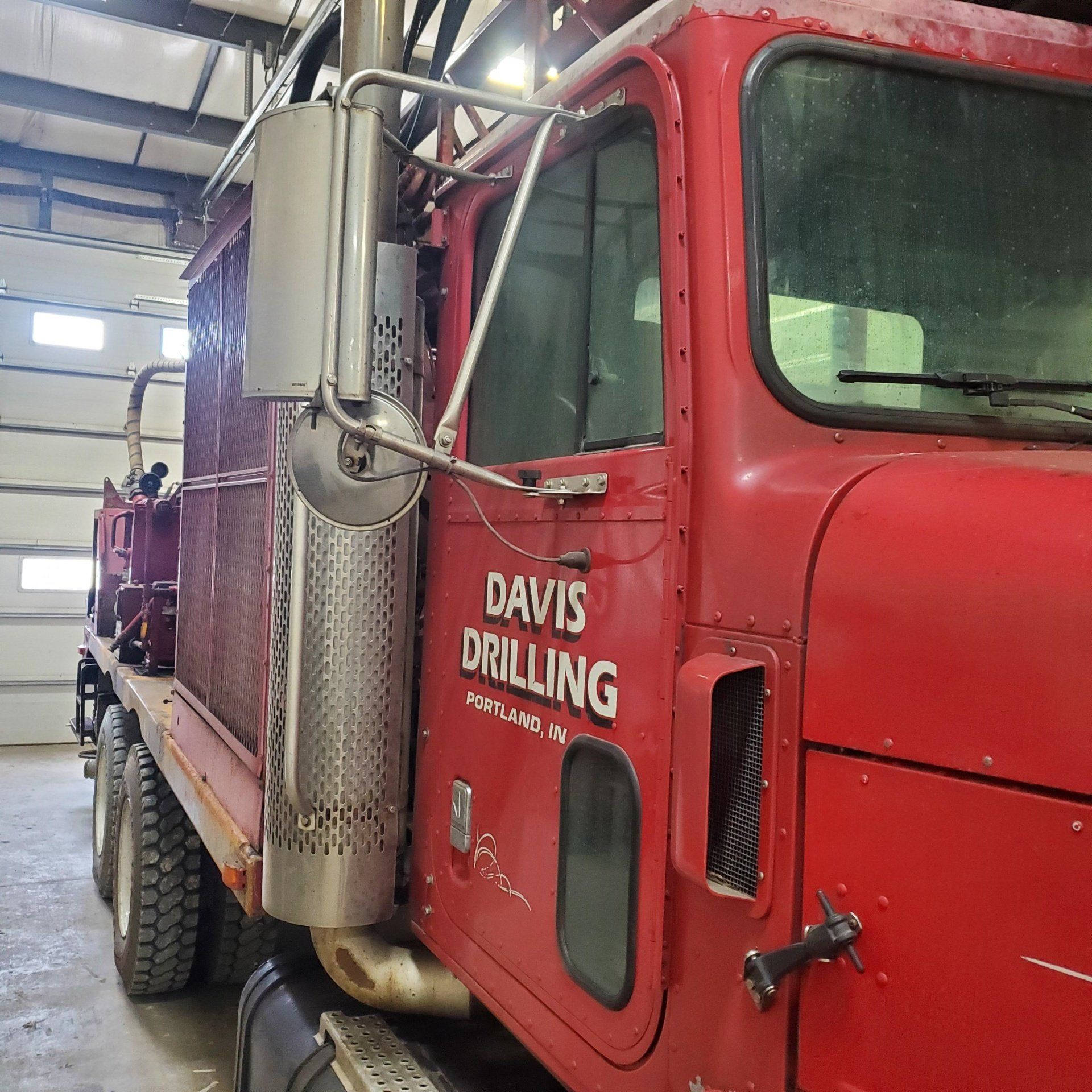 Red Davis Drilling truck parked in a garage.