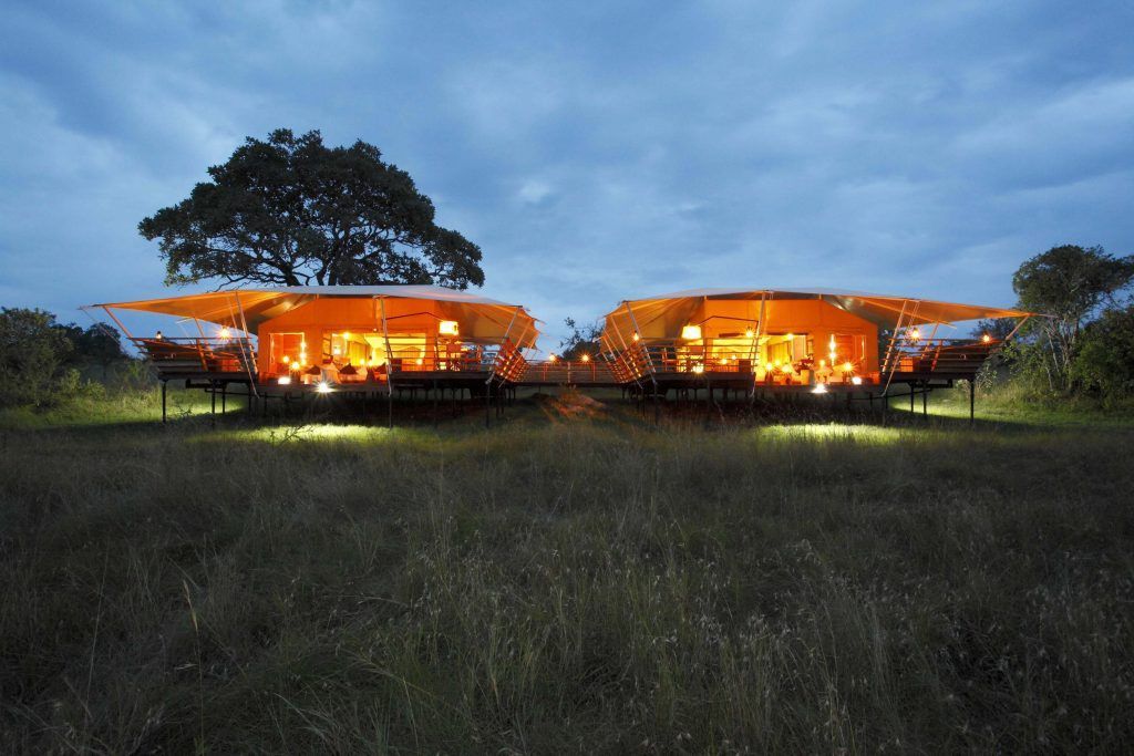 Two buildings are lit up in the middle of a field