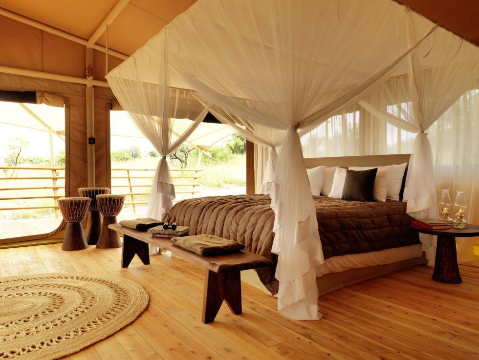A bedroom with a canopy bed and a rug