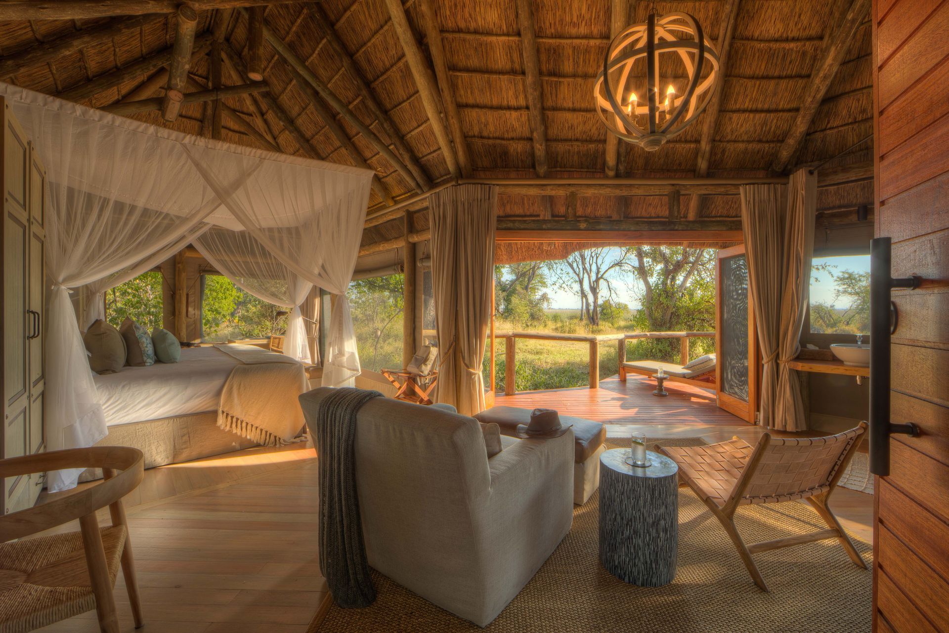 A living room with a canopy bed , chairs , and a table.