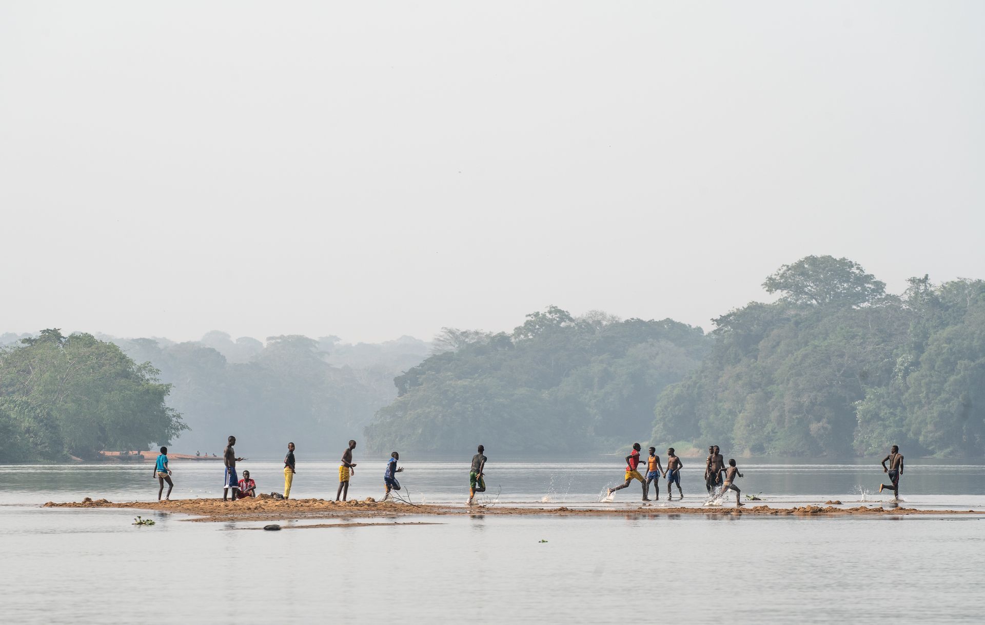 A group of people are walking across a river on rafts.