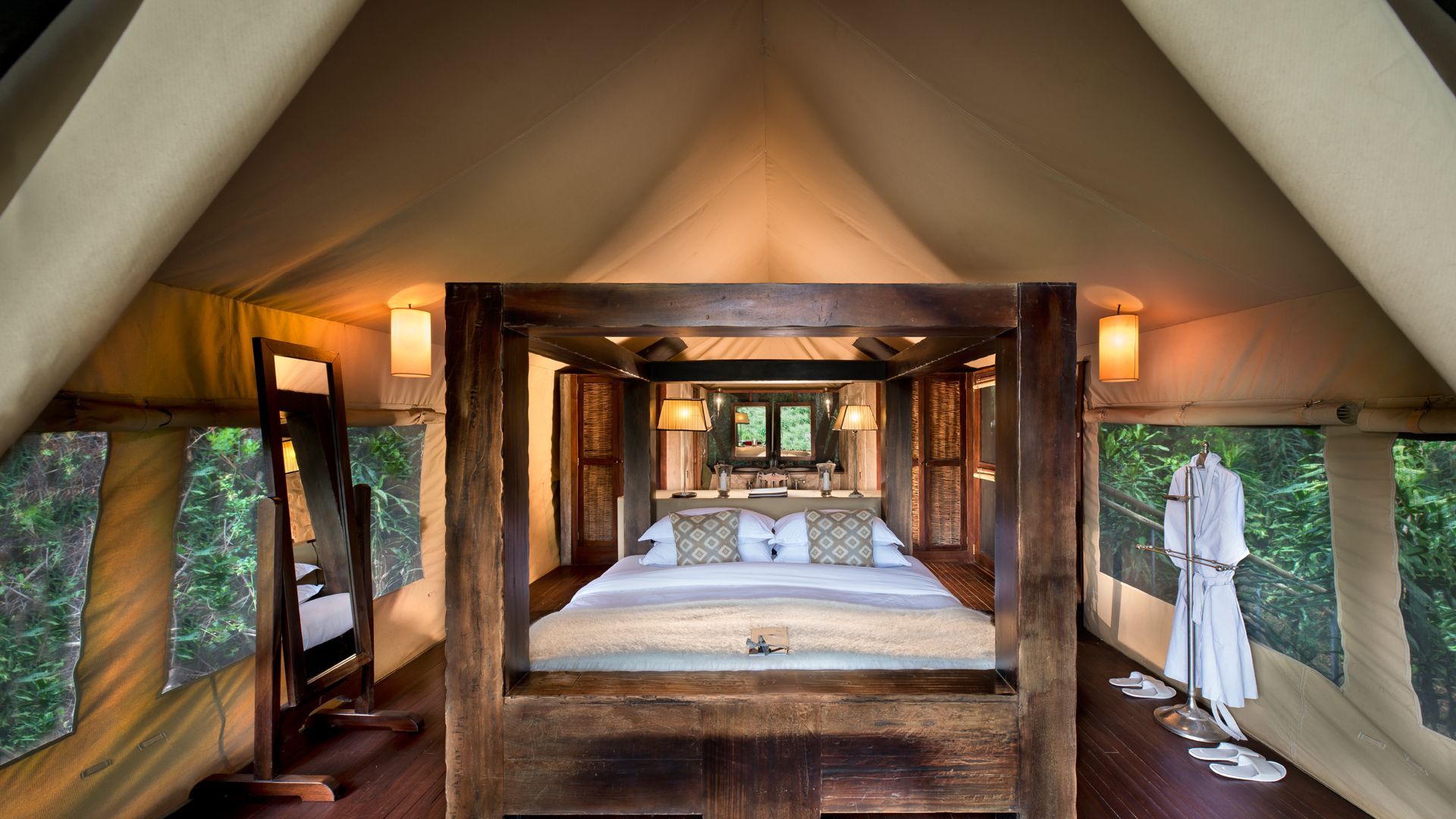 A bedroom with a four poster bed and a mirror