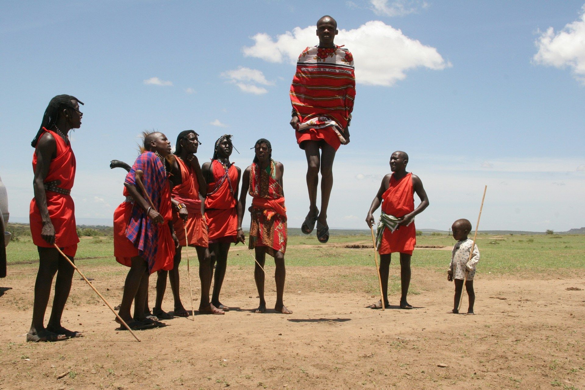 A group of people are jumping in the air in a field