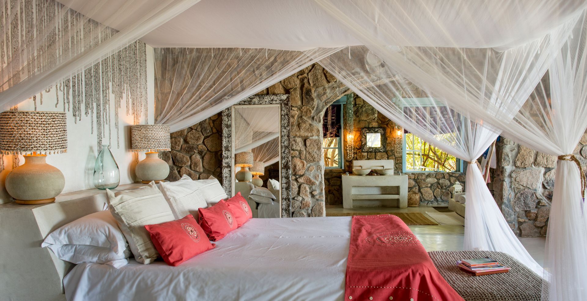 A bedroom with a canopy bed and a bathroom.