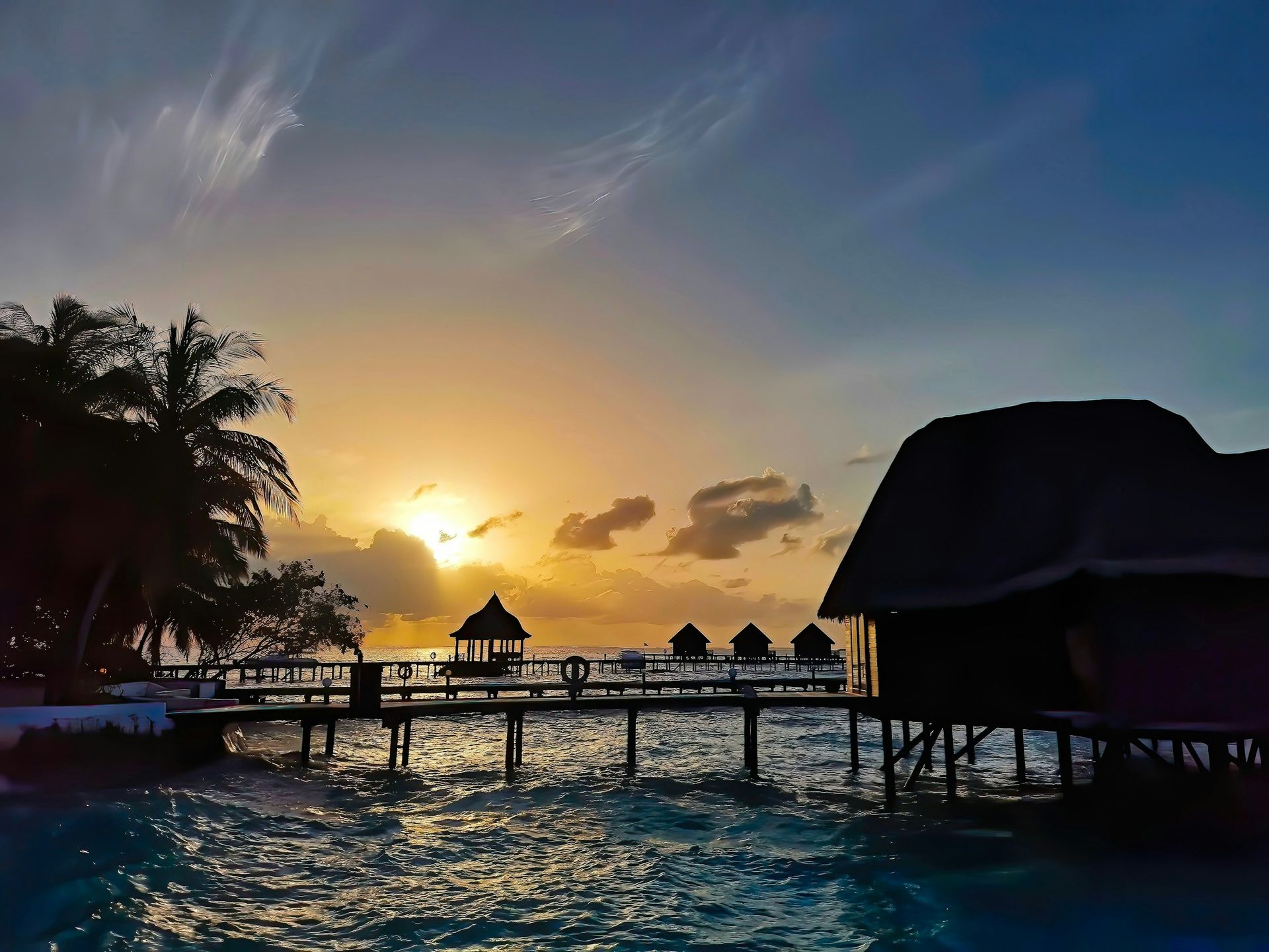 A sunset over a body of water with a dock in the foreground