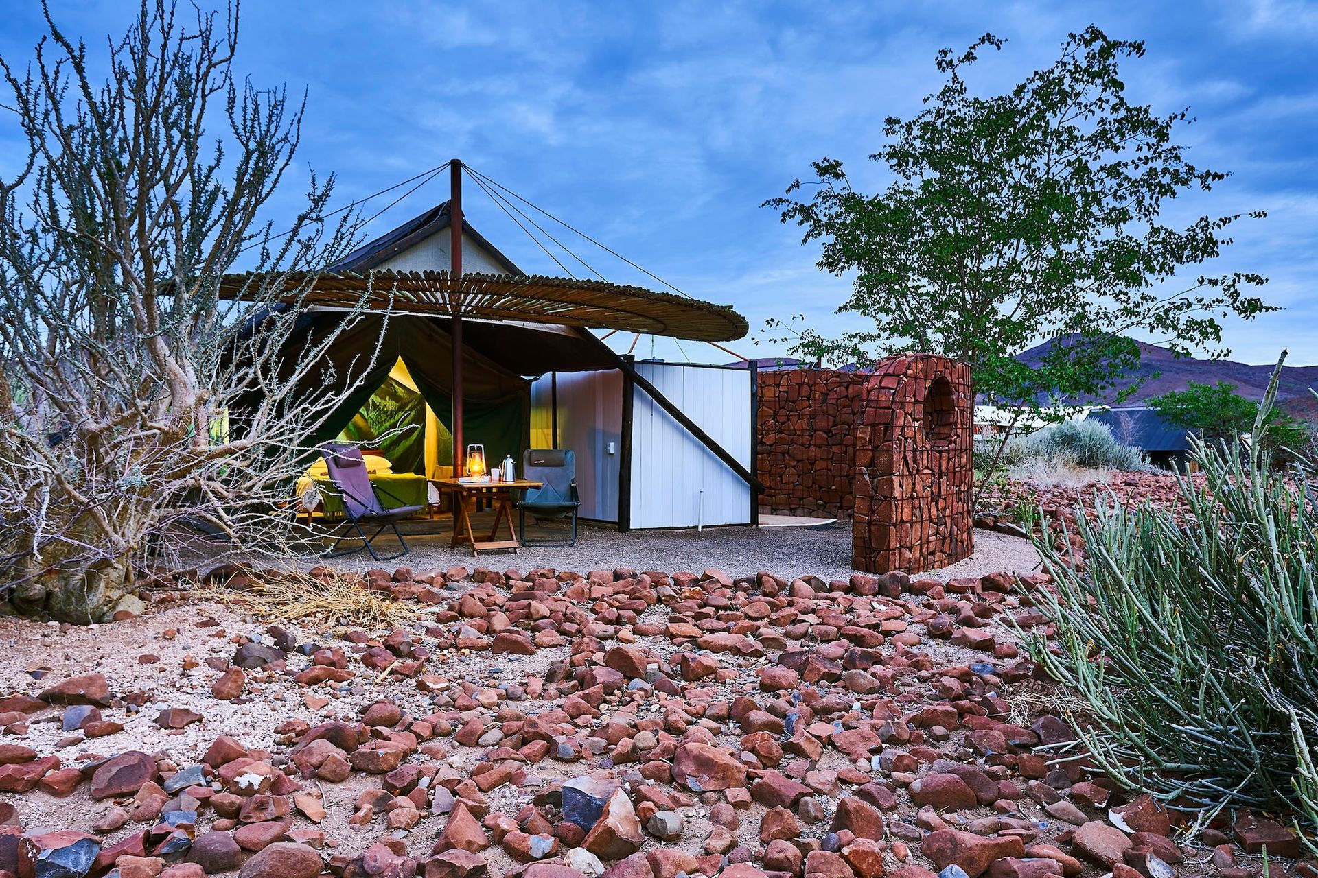 A tent is sitting in the middle of a rocky field.