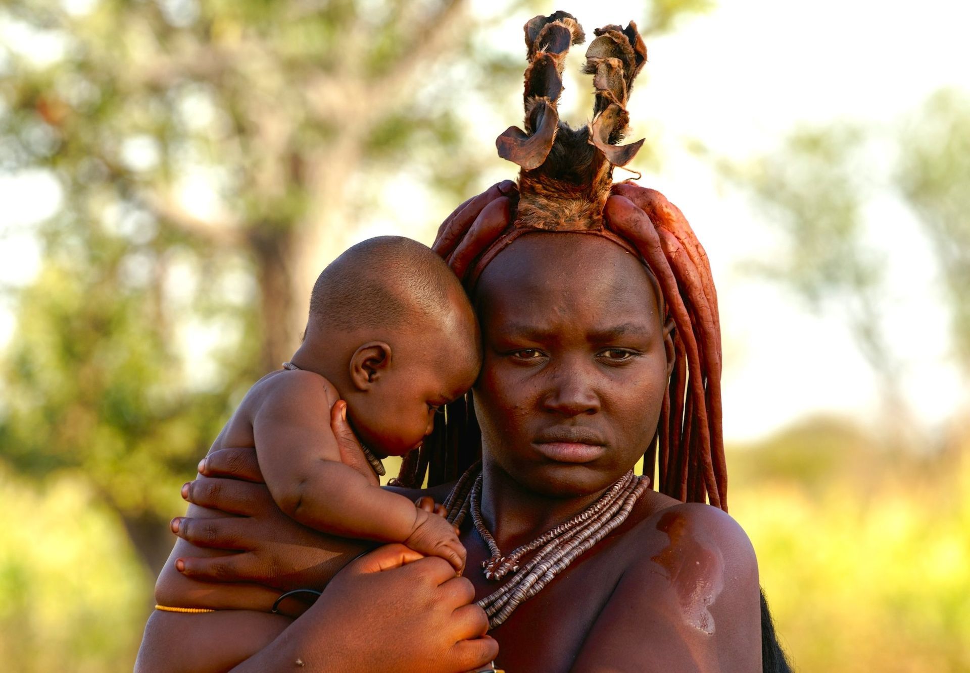A woman with red hair is holding a baby in her arms