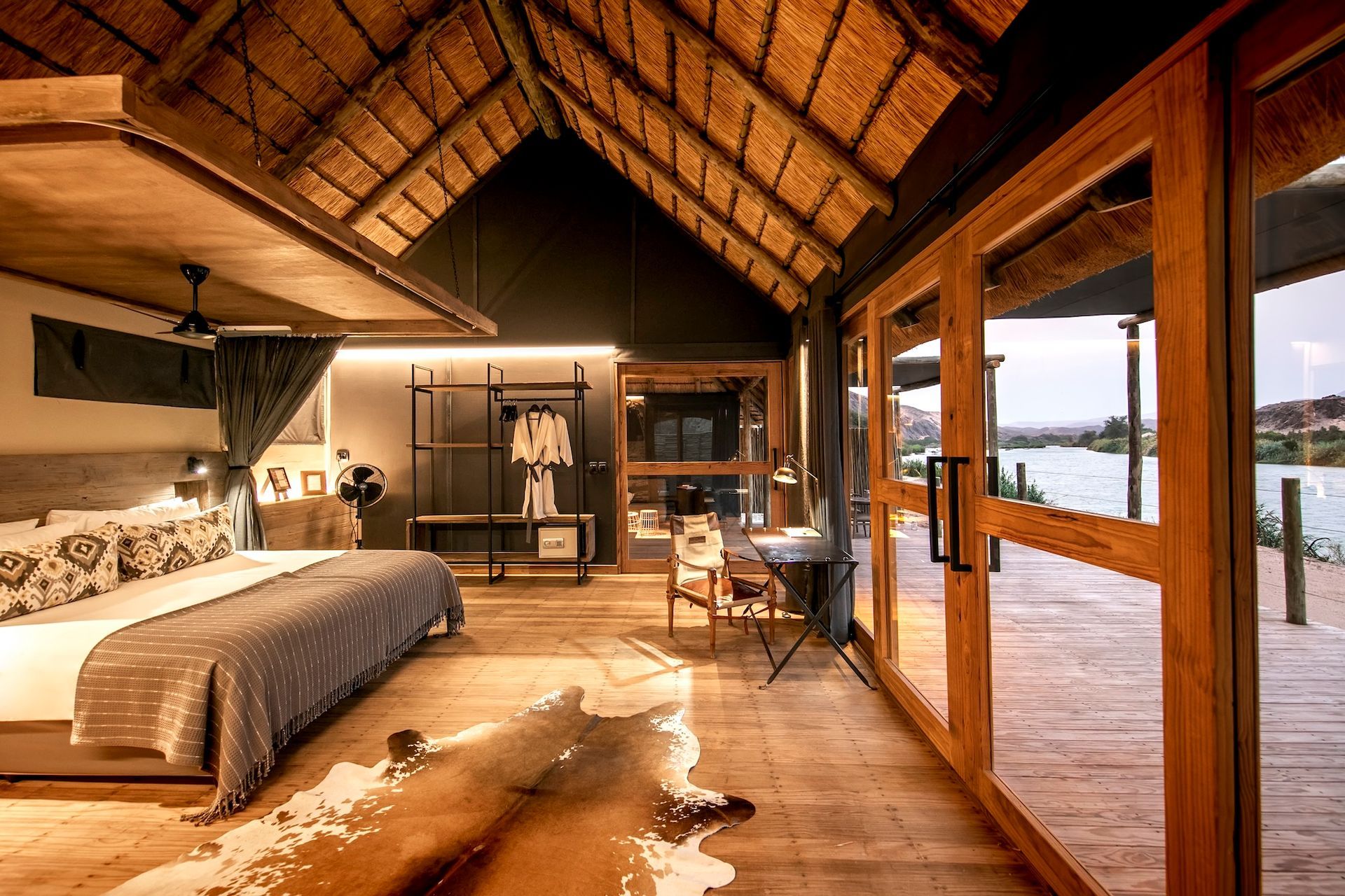 A bedroom with a king size bed , desk , and sliding glass doors.