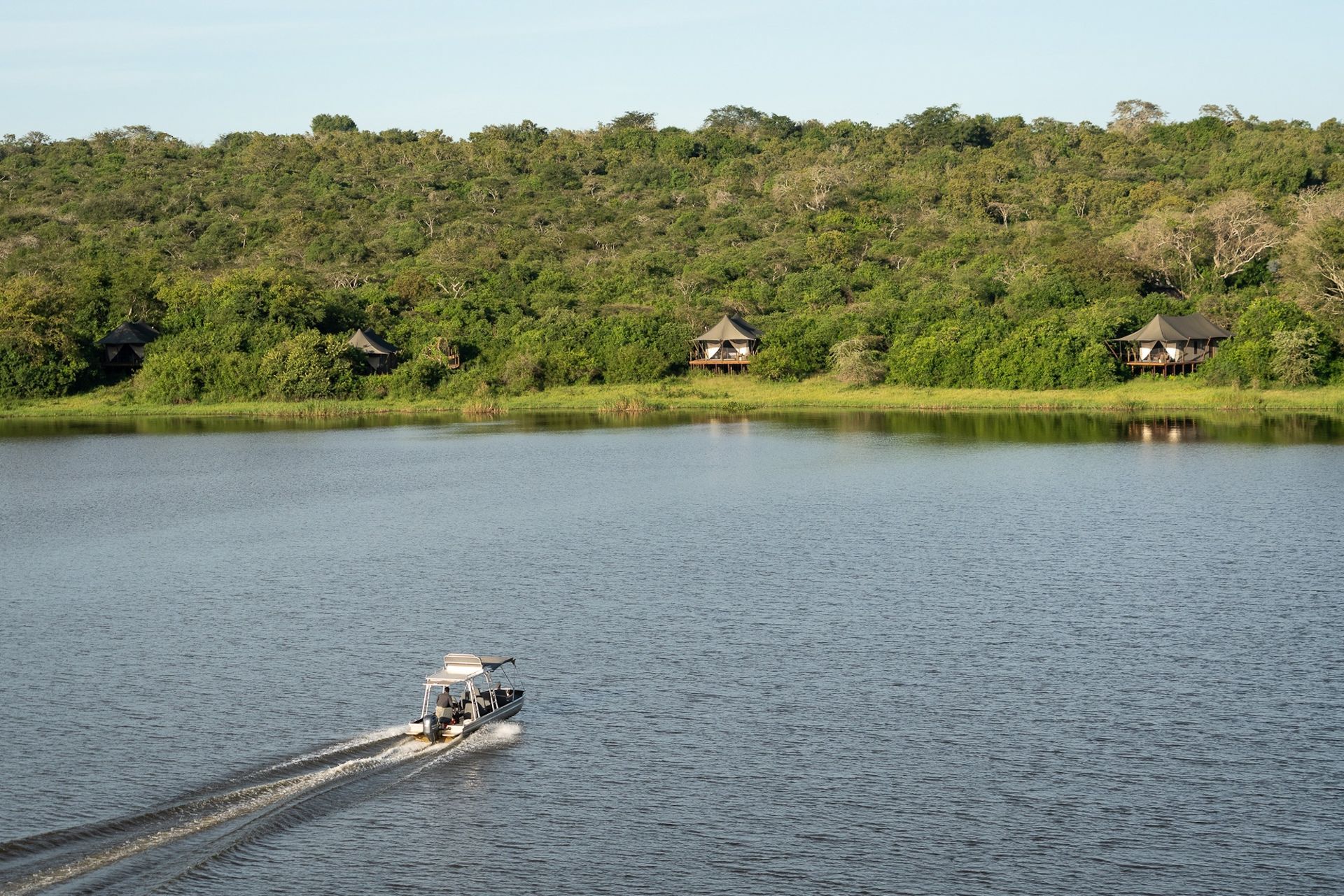 A boat is floating on a lake with trees in the background